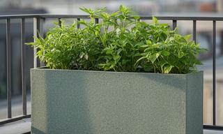Fioriera rettangolare in materiale riciclato con piante verdi su un terrazzo